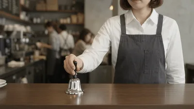 Barista Rings Service Bell On Coffee Shop Counter