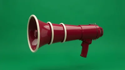 Red Megaphone Floating Against A Solid Green Background