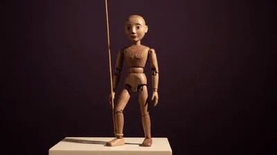 Wooden Articulated Mannequin Lowering Its Leg
