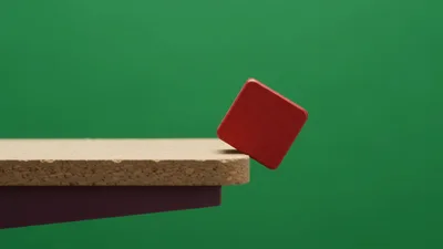 Red Wooden Cube Falling Off A Cork Platform