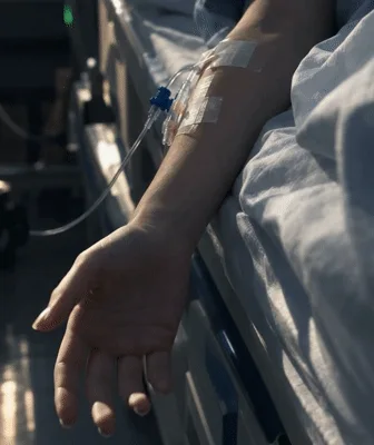 Patient Hand Dropping Pen While Lying In Hospital Bed