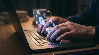 Person Typing On Laptop With Digital Cloud Computing Icons