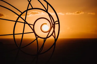 Sunset Viewed Through A Metal Spiral Sculpture