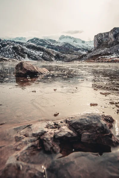 Frozen Alpine Lake With Snow Covered Mountains