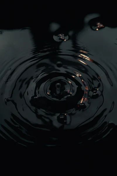 Water Droplet Creating Concentric Ripples In Dark Liquid