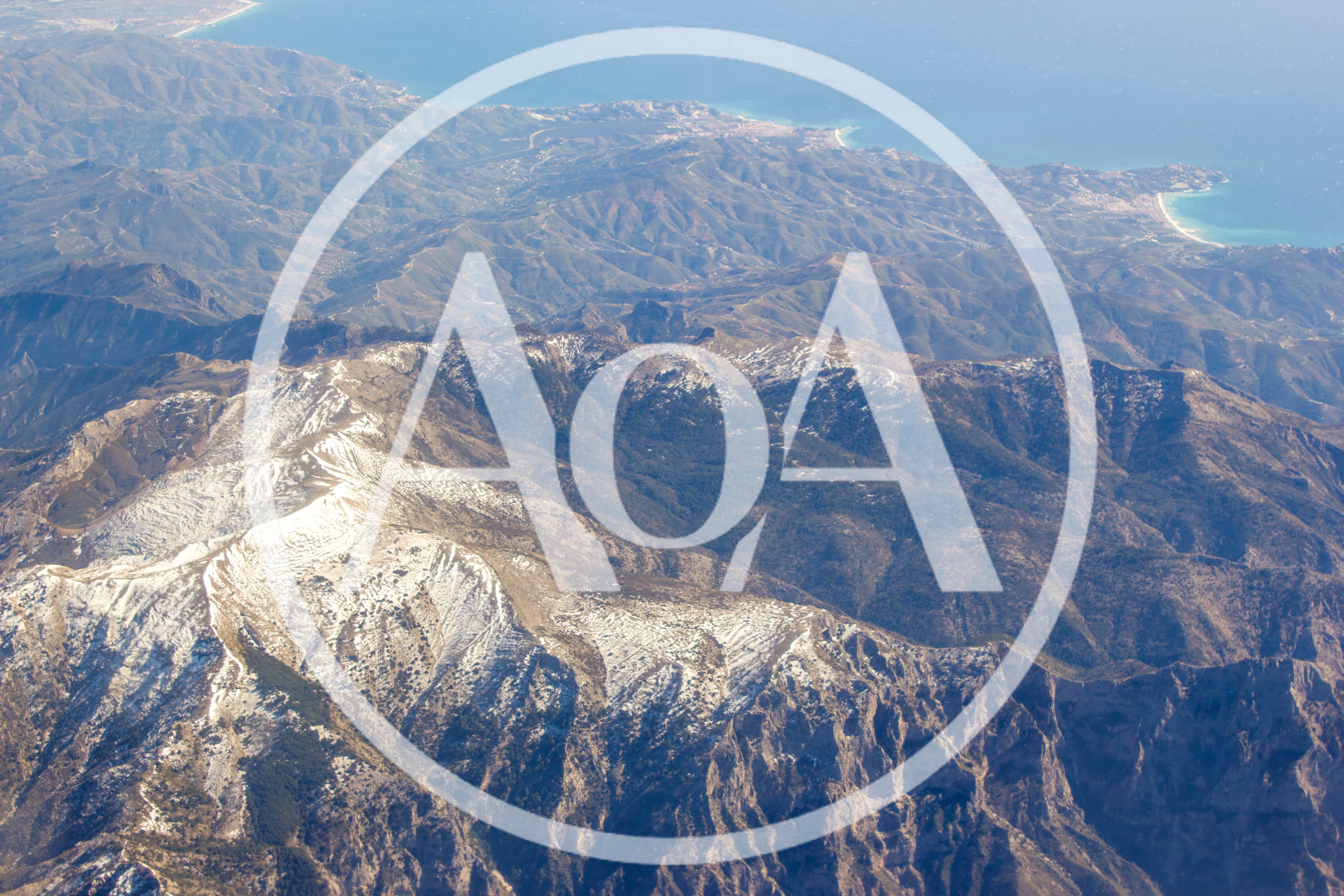 Aerial View Of Snow Capped Mountains Near Coastline