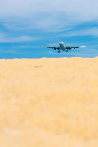 Commercial Airplane Landing Over Sandy Beach