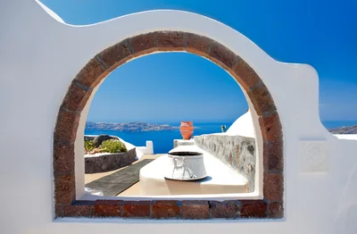 Framed View Of Santorini Caldera Through Stone Archway