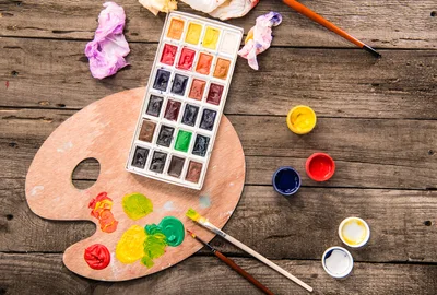Watercolor Paint Set and Wooden Palette on Rustic Table