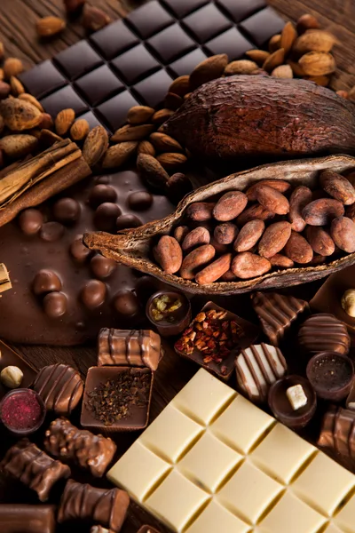 Assorted Chocolate Bars and Cocoa Beans on Wooden Table