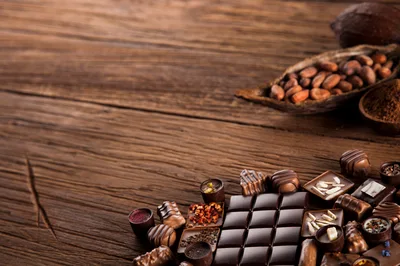 Assorted Gourmet Chocolates and Cocoa Beans on Wooden Table