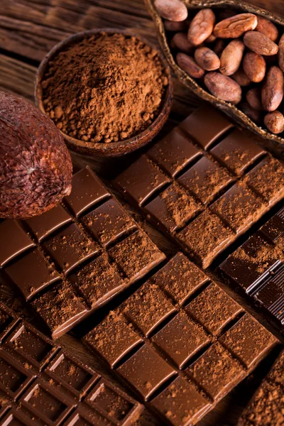 Dark Chocolate Bars and Cocoa Beans on Wooden Table