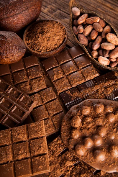 Assorted Chocolate Bars and Cocoa Beans on Wooden Table