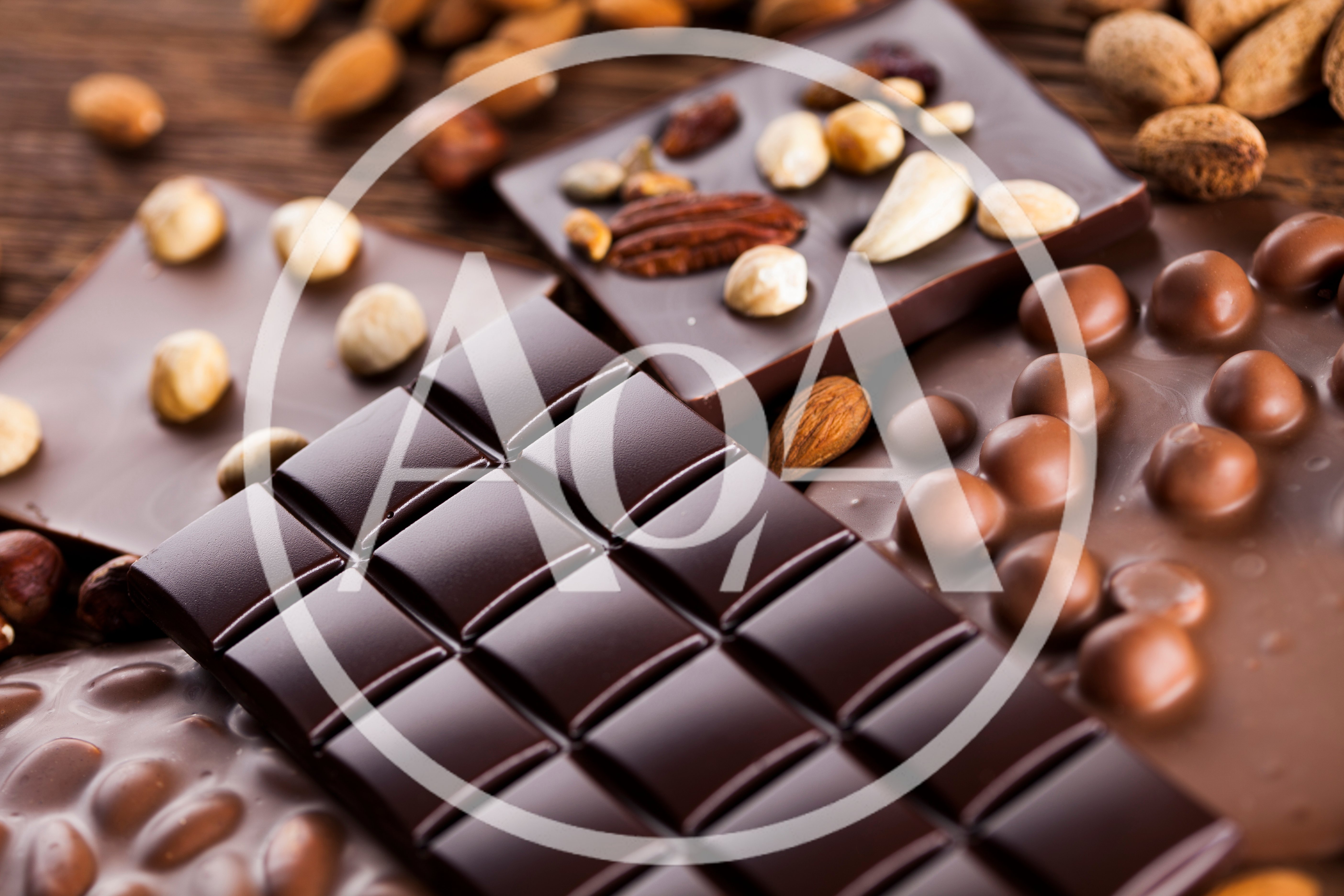 Assorted Chocolate Bars With Nuts On Wooden Background