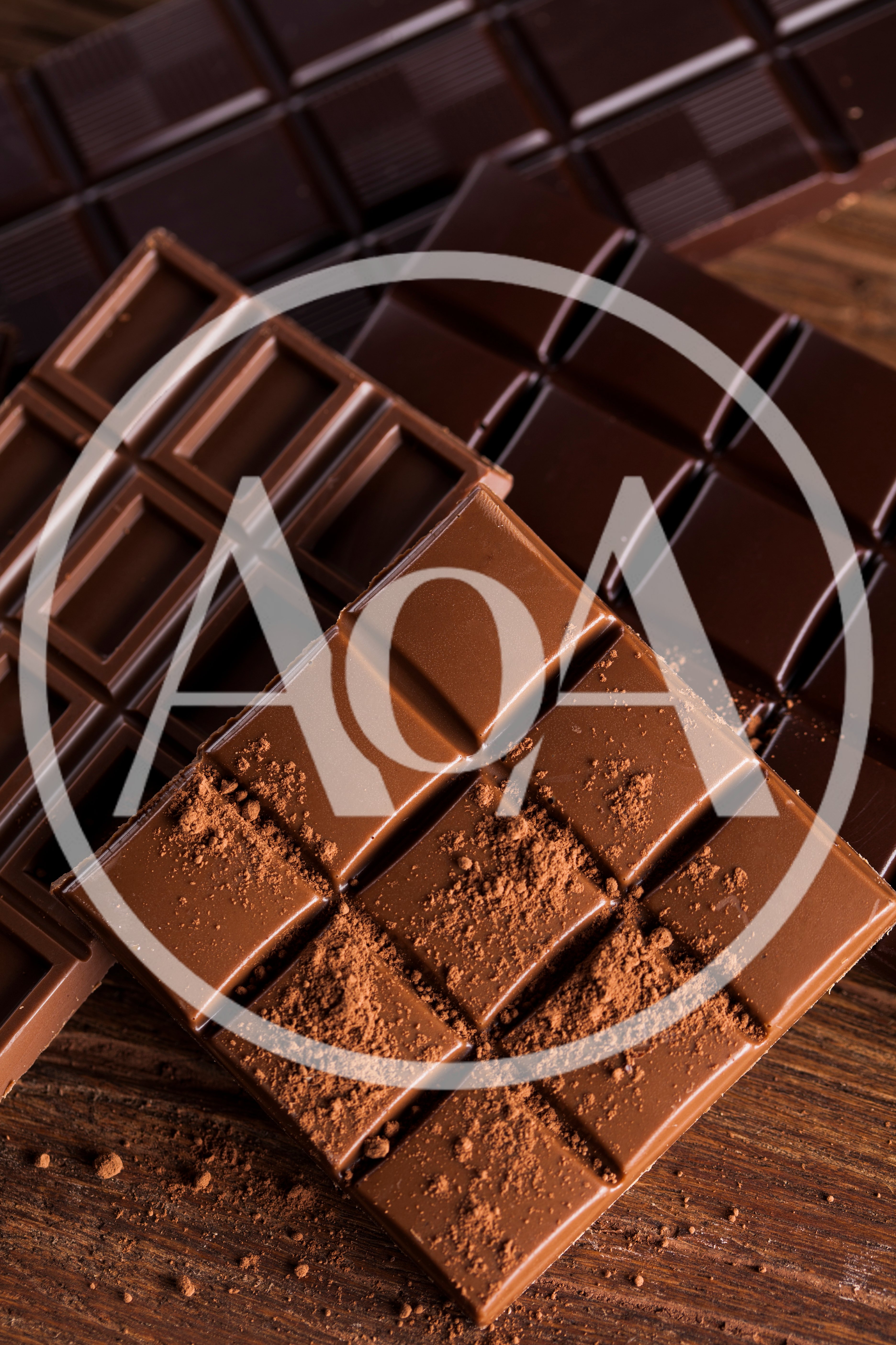 Assorted Chocolate Bars With Cocoa Powder On Wooden Surface
