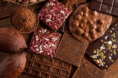Assorted Chocolate Bars and Cocoa Ingredients on Wooden Table
