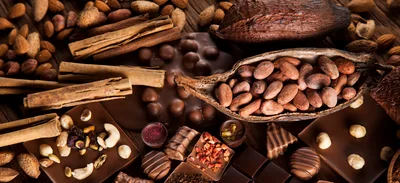 Assorted Chocolate Bars and Cocoa Beans on Wooden Table