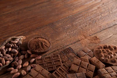 Assorted Chocolate Bars and Cocoa Beans on Wooden Table