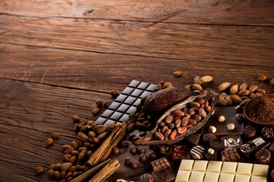 Assorted Chocolate Bars and Cocoa Beans on Wooden Table