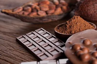 Dark Chocolate Bar And Cocoa Powder On Wooden Table