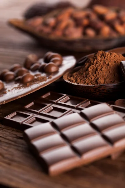 Assorted Chocolate Bars and Cocoa Powder on Wooden Table
