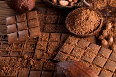 Assorted Chocolate Bars and Cocoa Powder on Wooden Table