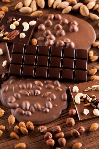Assorted Chocolate Bars With Nuts On Wooden Background