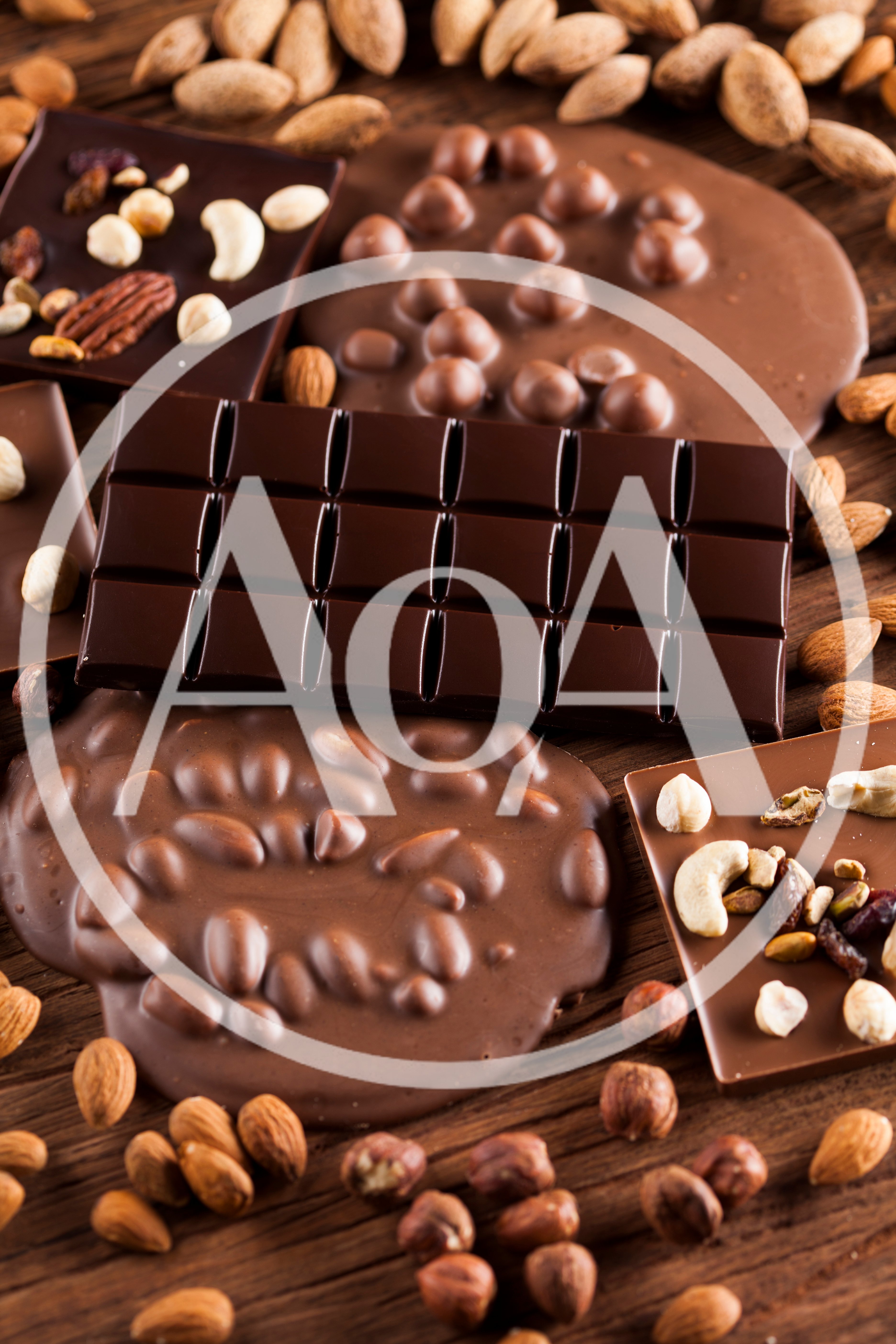 Assorted Chocolate Bars With Nuts On Wooden Background
