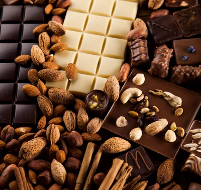 Assorted Chocolate Bars and Nuts on Wooden Table