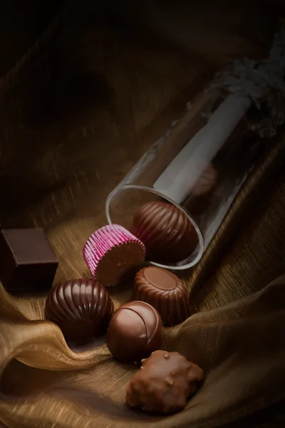 Assorted Gourmet Chocolates Spilled From A Glass