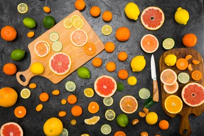 Assorted Citrus Fruits Arranged on Dark Stone Surface