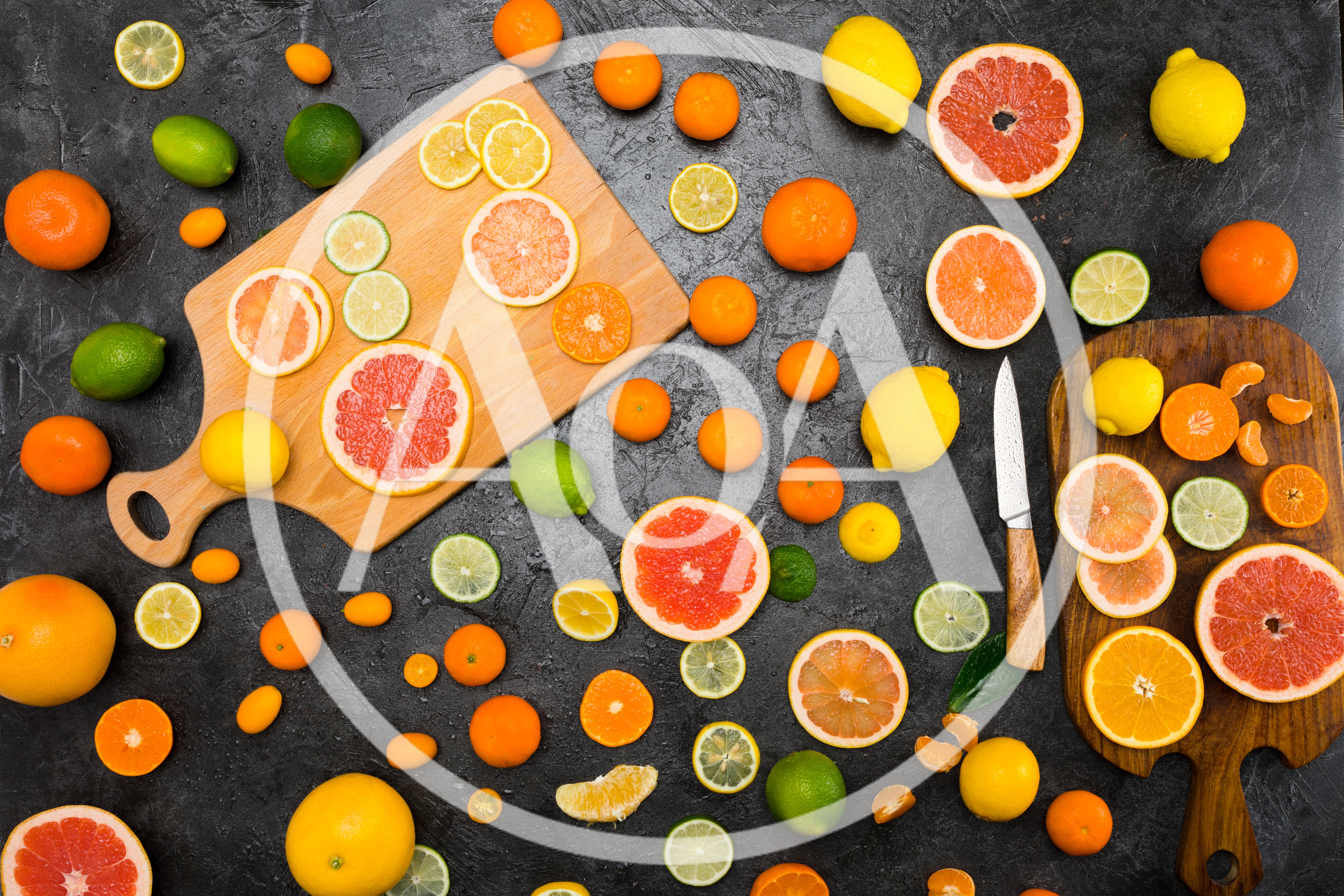 Assorted Citrus Fruits Arranged on Dark Stone Surface