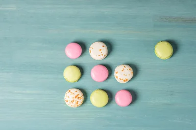 Colorful Macarons Arranged In A Grid On Blue Wood