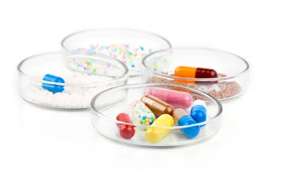Assorted Pharmaceutical Capsules and Granules in Glass Petri Dishes