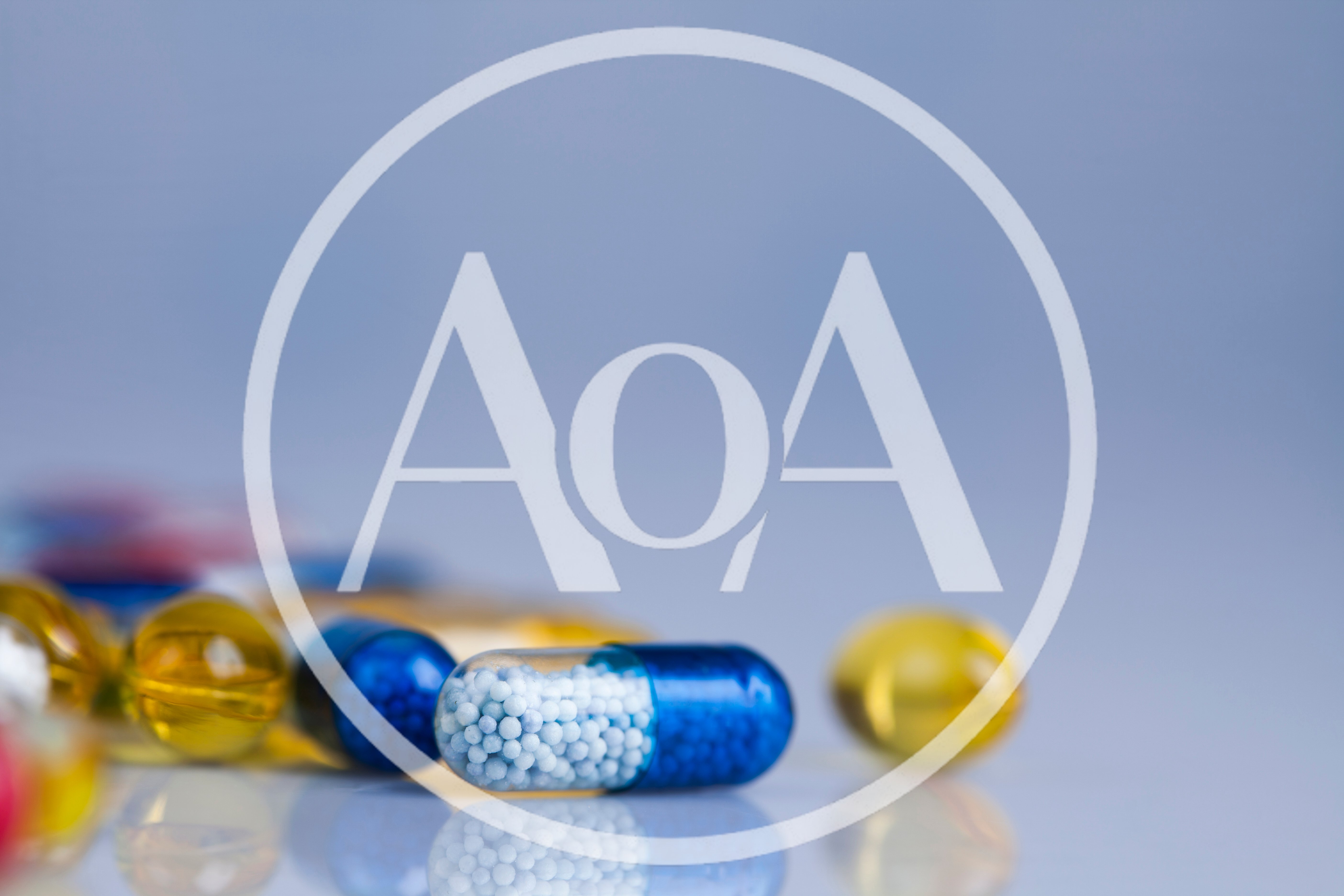 Blue And Yellow Medical Capsules On Reflective Surface