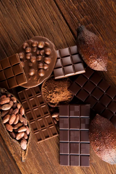Assorted Chocolate Bars and Cocoa Beans on Wooden Table