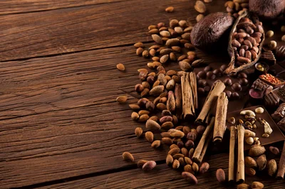 Assorted Cocoa Beans And Spices On Wooden Table