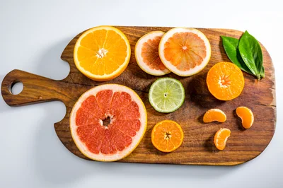 Assorted Citrus Fruit Slices On A Wooden Cutting Board