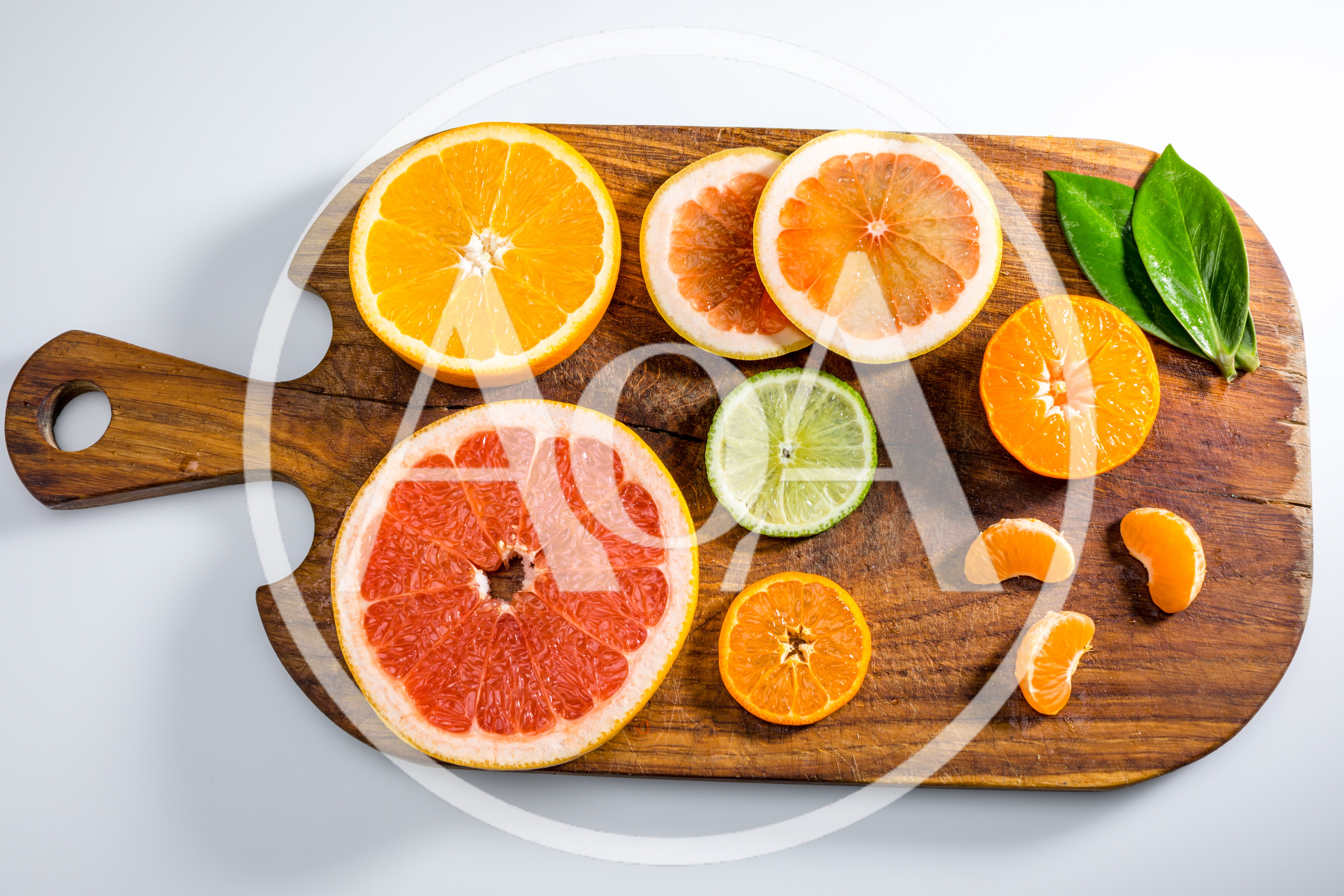 Assorted Citrus Fruit Slices On A Wooden Cutting Board