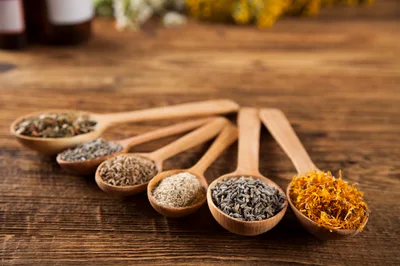 Wooden Spoons Filled With Assorted Dried Herbs And Flowers