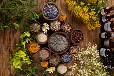 Assorted Dried Herbs And Flowers In Wooden Bowls