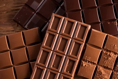 Assorted Chocolate Bars On A Rustic Wooden Surface