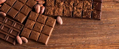 Dark Chocolate Bars With Cocoa Beans On Wooden Table