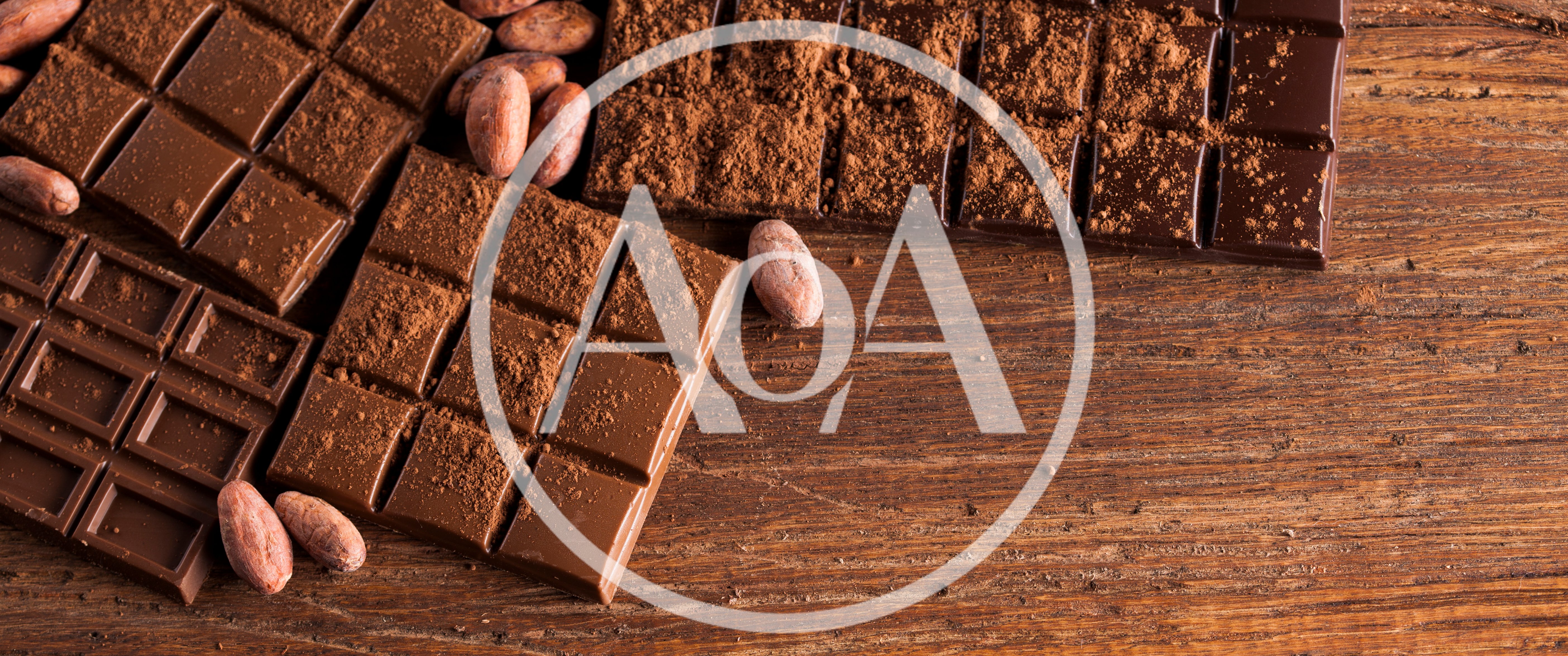 Dark Chocolate Bars With Cocoa Beans On Wooden Table