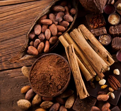 Cocoa Beans And Cinnamon Sticks On Wooden Table