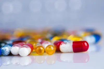 Assorted Pharmaceutical Capsules and Pills on Reflective Surface