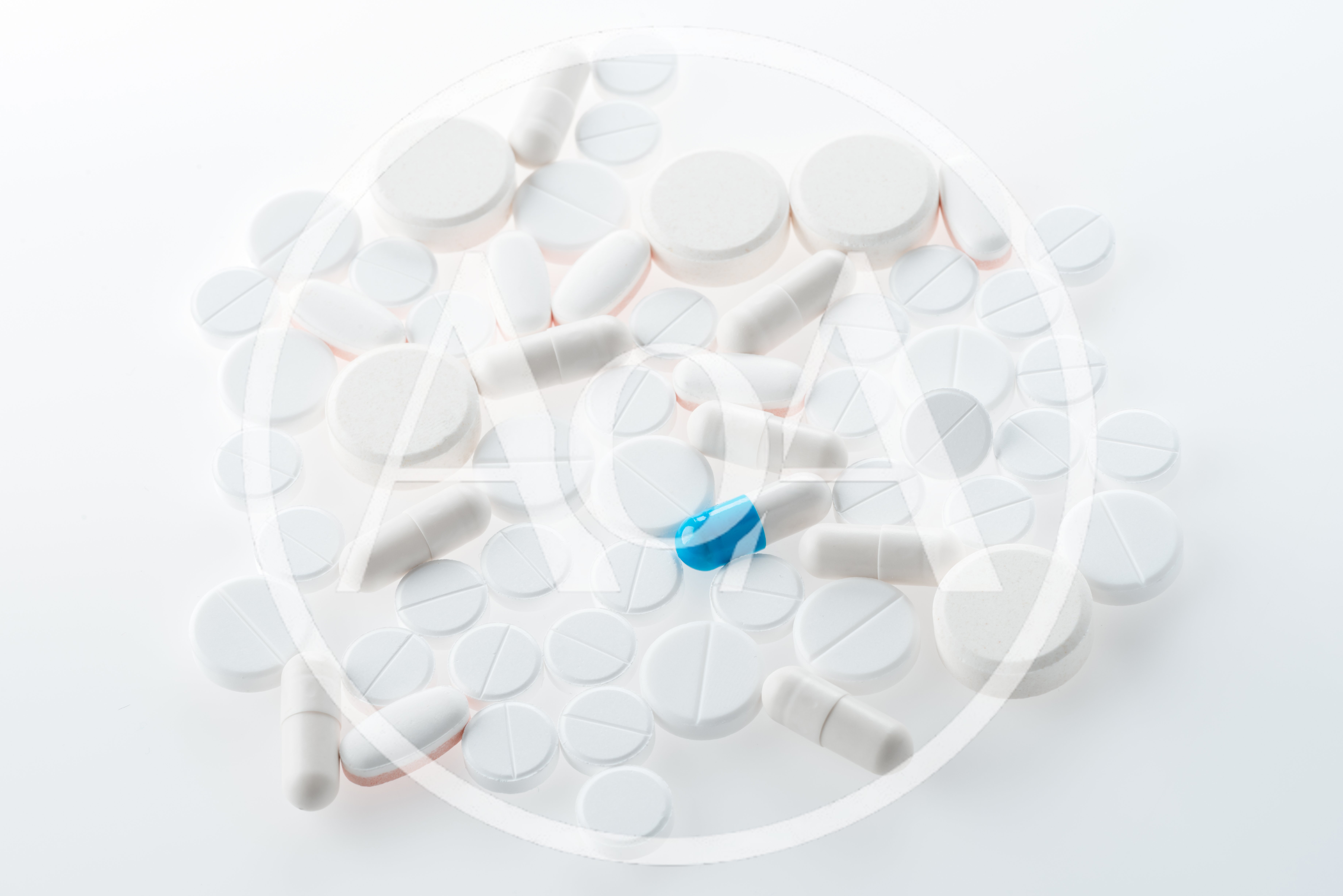 Assorted White Pills and Capsules on White Background