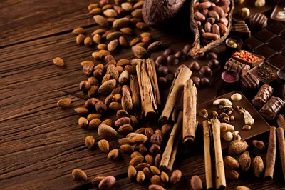 Assorted Nuts Spices And Chocolate On Wooden Table
