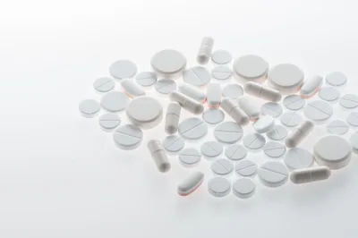 Assorted White Medical Pills And Capsules On White Background