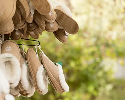 Tan Suede Slippers Hanging On A Retail Display Rack